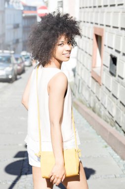 Poz, gülümseyen afro kızla.