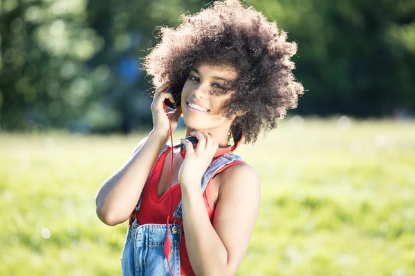 Afrikanische Amerikanerin entspannt sich im Freien mit Kopfhörern. — Stockfoto