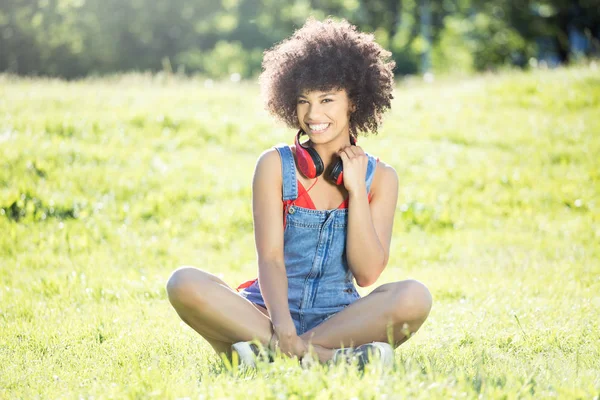 アフリカ系アメリカ人女の子のヘッドフォンを屋外でリラックス. — ストック写真
