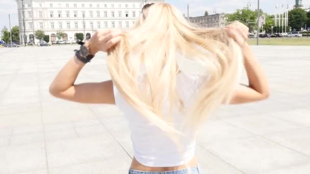 Vacker ung kaukasiska flicka gå på staden, bär moderiktiga solglasögon och korta jeans, solig sommardag. — Stockvideo