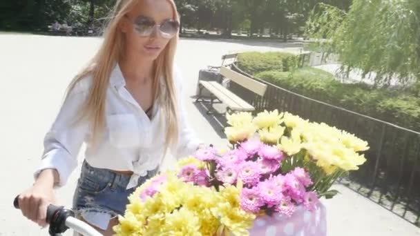 Blondin kaukasiska flicka cykling i stadsparken på solig dag. — Stockvideo