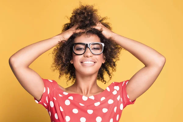 African american flicka i glasögon på gul bakgrund. — Stockfoto