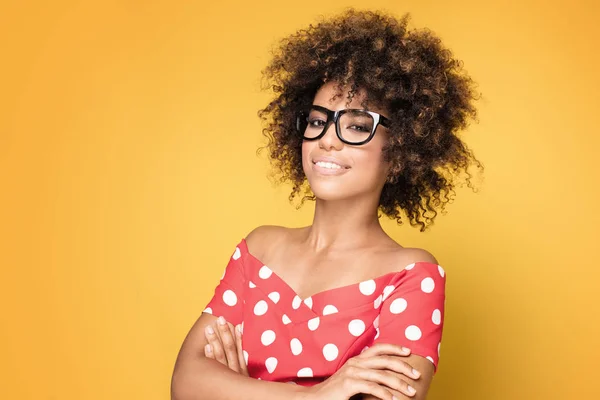 Afrikanische Amerikanerin mit Brille auf gelbem Hintergrund. — Stockfoto