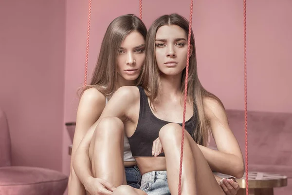 Foto de moda de atractivas hermanas gemelas caucásicas posando en pi —  Fotos de Stock