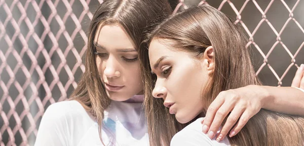 Tvillingar kvinnliga modeller poserar utomhus. — Stockfoto