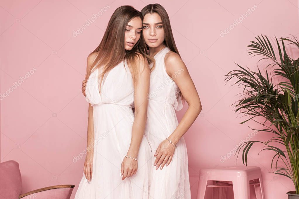 Two female models posing in elegant dresses.