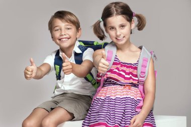 İki çocuk sırt çantaları ile poz.