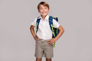 Sırt çantası ile gülümseyen küçük çocuk.