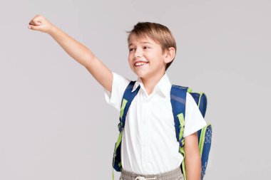 Sırt çantası ile gülümseyen küçük çocuk.