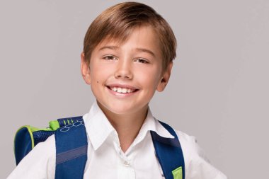 Sırt çantası ile gülümseyen küçük çocuk.