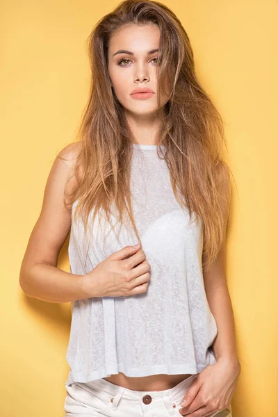 Hermosa joven caucásica posando sobre fondo amarillo . — Foto de Stock