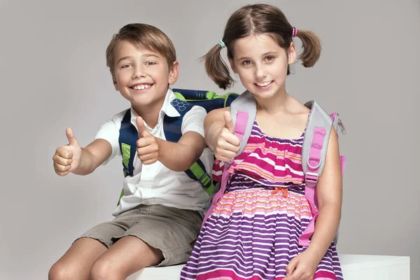 İki çocuk sırt çantaları ile poz.