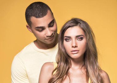 Güzel çift sarı arka plan üzerinde poz.