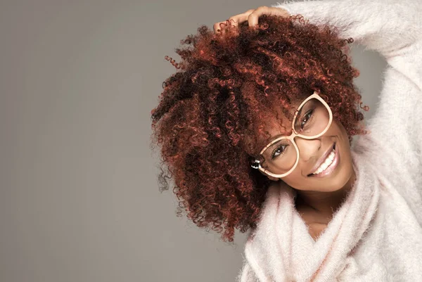 Happy woman with afro hairstyle smiling.