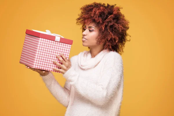 Афро девушка позирует с подарочной коробкой, улыбаясь . — стоковое фото