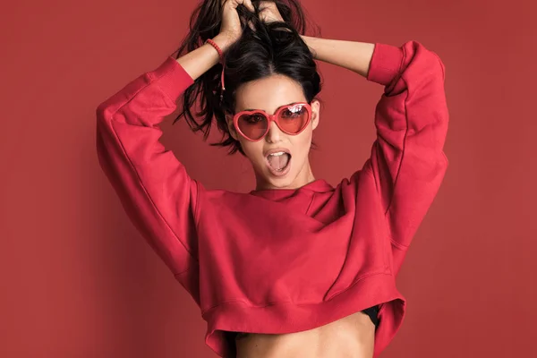 Mujer hermosa de moda posando sobre fondo rojo . — Foto de Stock