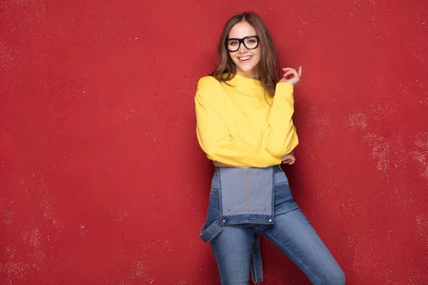 Happy girl smiling, standing on red background. — Stock Photo, Image