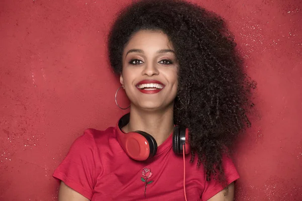 Chica feliz sonriendo, de pie sobre fondo rojo . — Foto de Stock