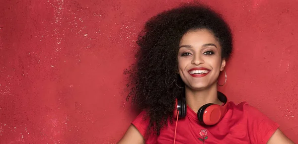 Chica feliz sonriendo, de pie sobre fondo rojo . — Foto de Stock