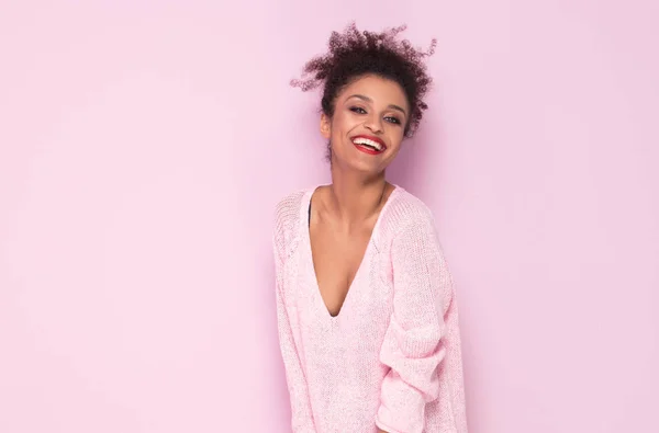 Joyeux afro fille avec un sourire étonnant posant sur fond rose . — Photo