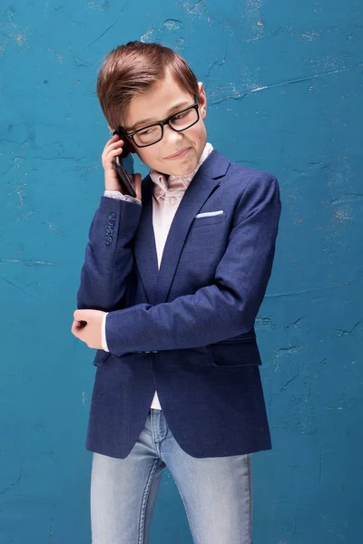 戴眼镜的聪明男孩用手机说话. — 图库照片