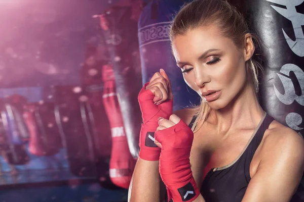 Boxeador femenino posando con saco de boxeo . — Foto de Stock