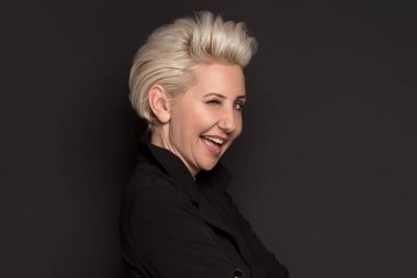 Poz, kameraya gülümseyen zarif sarışın güzel orta yaşlı bayan. Çekici işkadını.