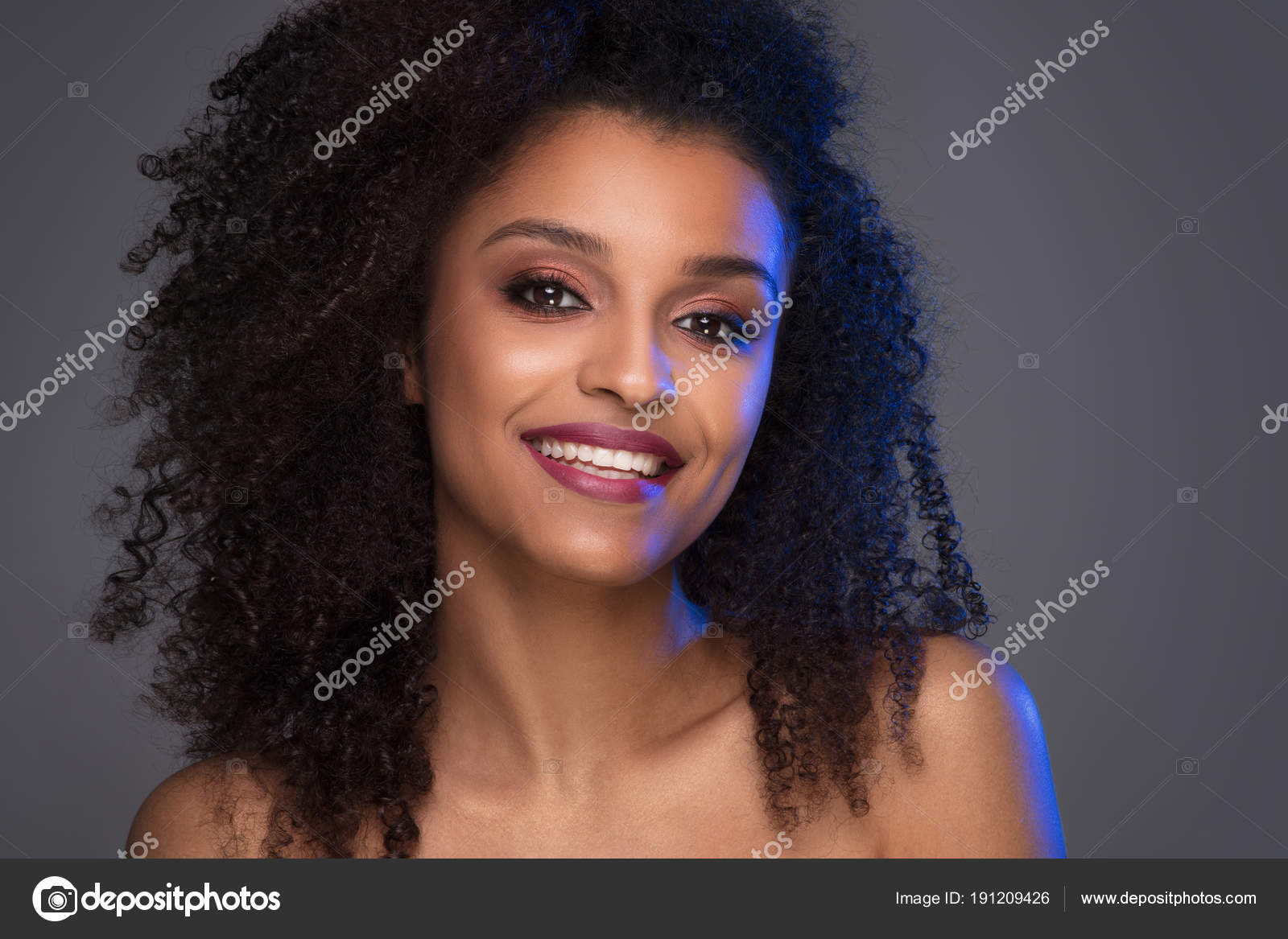 Beauty Portrait Lächelnd Dunkelhäutigen Jungen Frau Mit Lockigen Beauty Portrait lächelnd dunkelhäutigen jungen Frau mit lockigen Afro Haar und Glamour Make up Studio auf grauem Hintergrund Textfreiraum erschossen