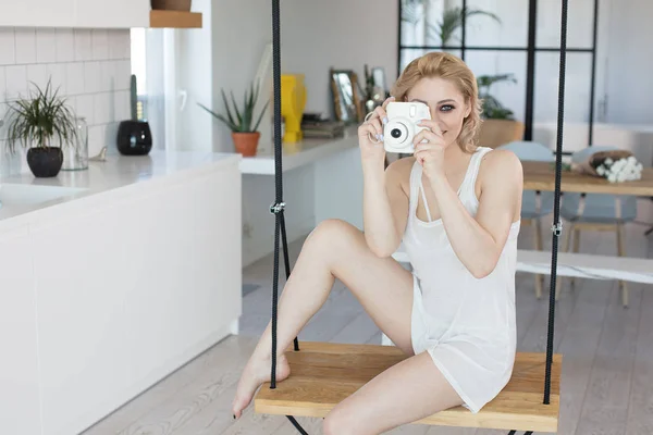 Blonde attractive girl taking photos at home. — Stock Photo, Image