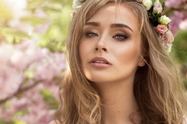 Çiçek bahçesinde hassas sarışın kız.