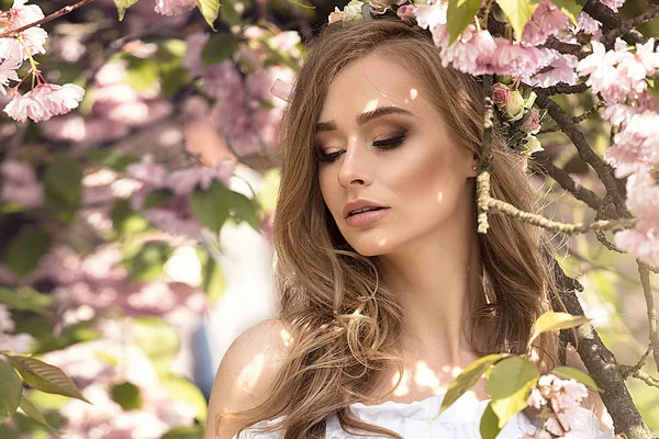Attraktiva blonda flicka i blommande trädgård. — Stockfoto