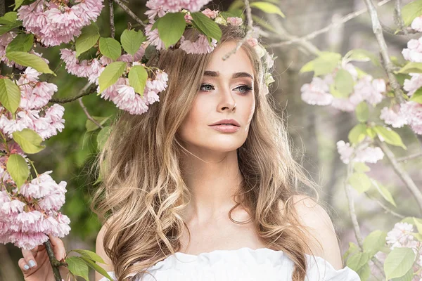 Attraktive blonde Mädchen im blühenden Garten. — Stockfoto