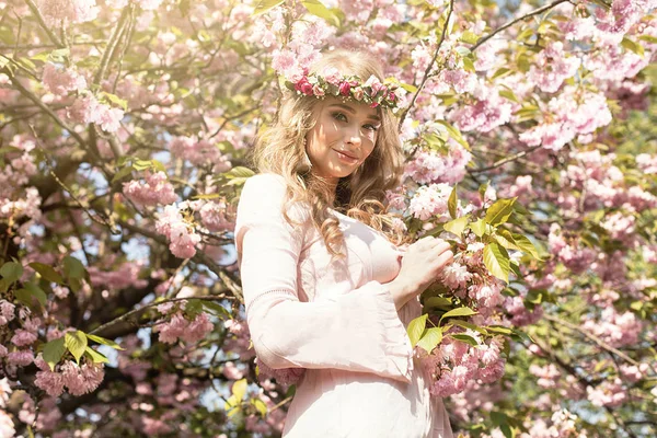 Delikat blond flicka i blommande trädgård. — Stockfoto