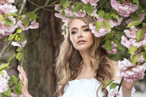 Attraktiva blonda flicka i blommande trädgård. — Stockfoto