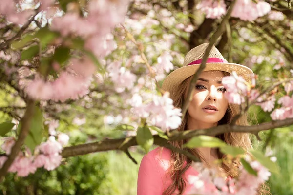 Attraktiva blonda flicka i blommande trädgård. — Stockfoto