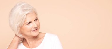 Gülümseyen yaşlı bayan arka plana bakıyor..