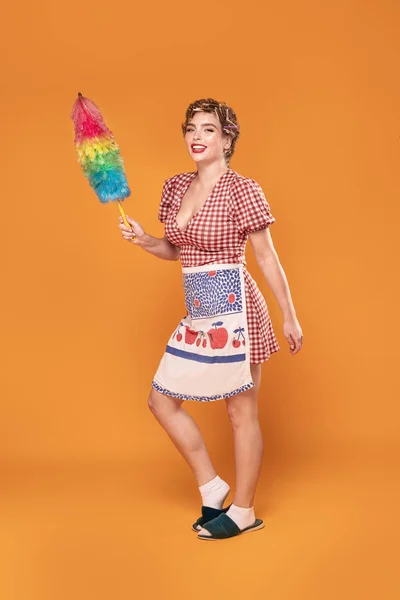 Sorrindo dona de casa segurar pincel espanador colorido . — Fotografia de Stock