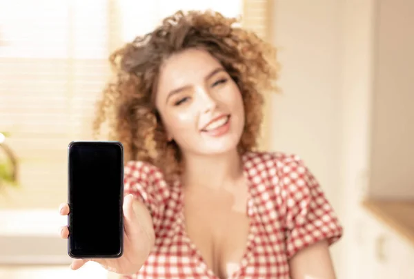 Sonriente chica mostrando un teléfono móvil . — Foto de Stock