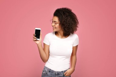 Gülümseyen afro kız boş cep telefonu ekranı gösteriyor.