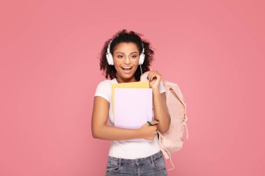 Sırt çantası ve defterleri olan mutlu öğrenci kız..