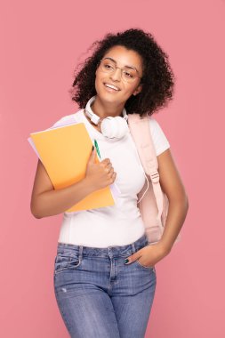 Sırt çantası ve defterleri olan mutlu öğrenci kız..