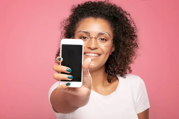 Lächelndes Afro-Mädchen mit leerem Handy-Bildschirm. — Stockfoto