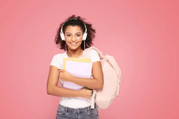 Glad student flicka med ryggsäck och anteckningsböcker. — Stockfoto