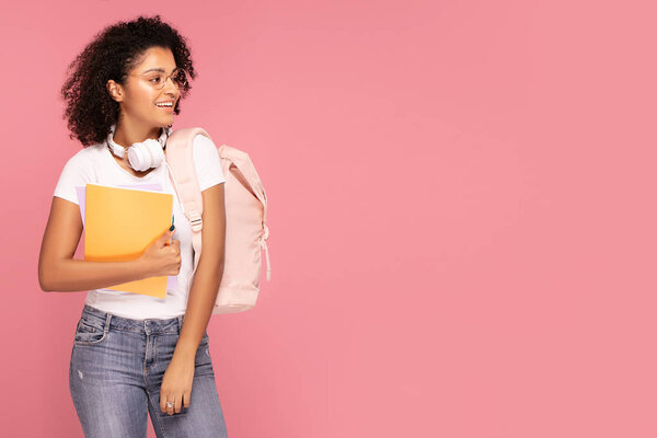 Happy student girl with backpack and notebooks.