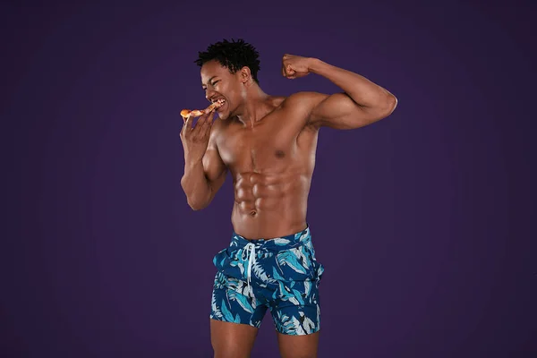 Fit afrikanischer Mann isst Pizza. — Stockfoto