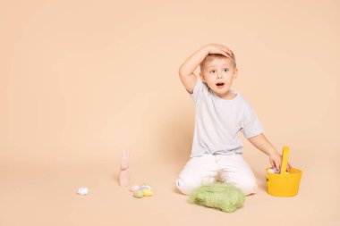 Paskalya sepeti ve yumurtaları olan küçük çocuk..