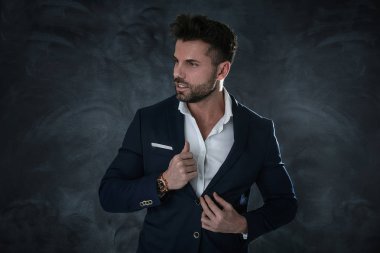 Portrait of handsome man in elegant suit on a dark background. Business style, businessman. Studio shot. clipart