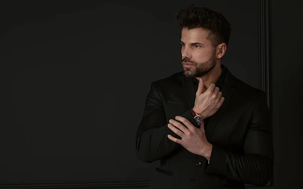 Portrait of a handsome man in elegant formal suit on a black background. Business style, businessman. Studio shot.