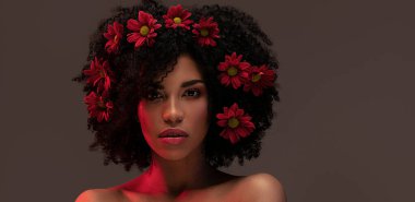 Saçında güzel çiçekler olan çekici bir afro kadın. Güzellik stüdyosu portresi.