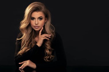 Uzun dalgalı saçlı zarif bir kadın. Seksi ve muhteşem sarışın kadın. Makyajlı, dumanlı gözleri olan güzel bir kızın yakın çekim yüzü..